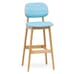 Front corner view of commercial bar stool in natural finish with blue upholstery fabric seat and back
